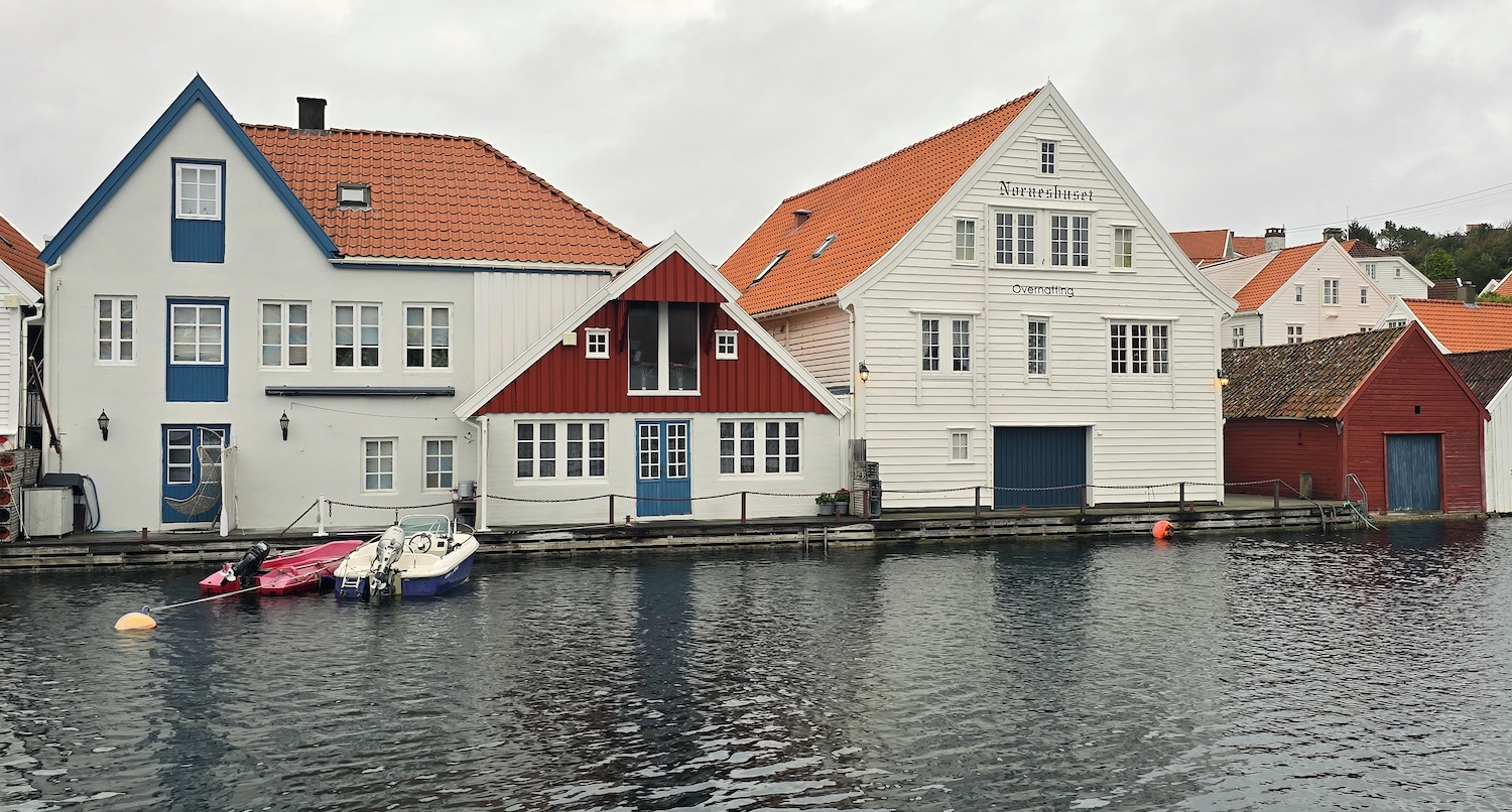 De to bygningene til venstre ble brukt av Skudenes Canning. I kjelleretasjen på Norneshuset (det store hvite) var det sildemottak. Foto: Erling Jensen.